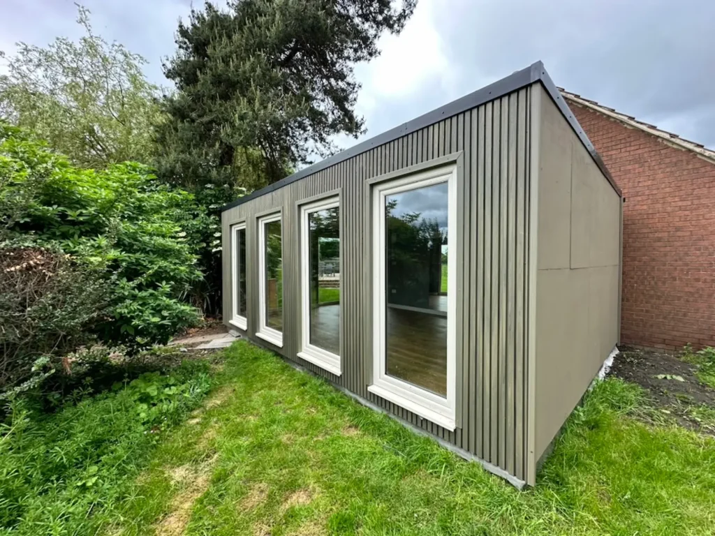 garden room clad in antique green slatted composite cladding